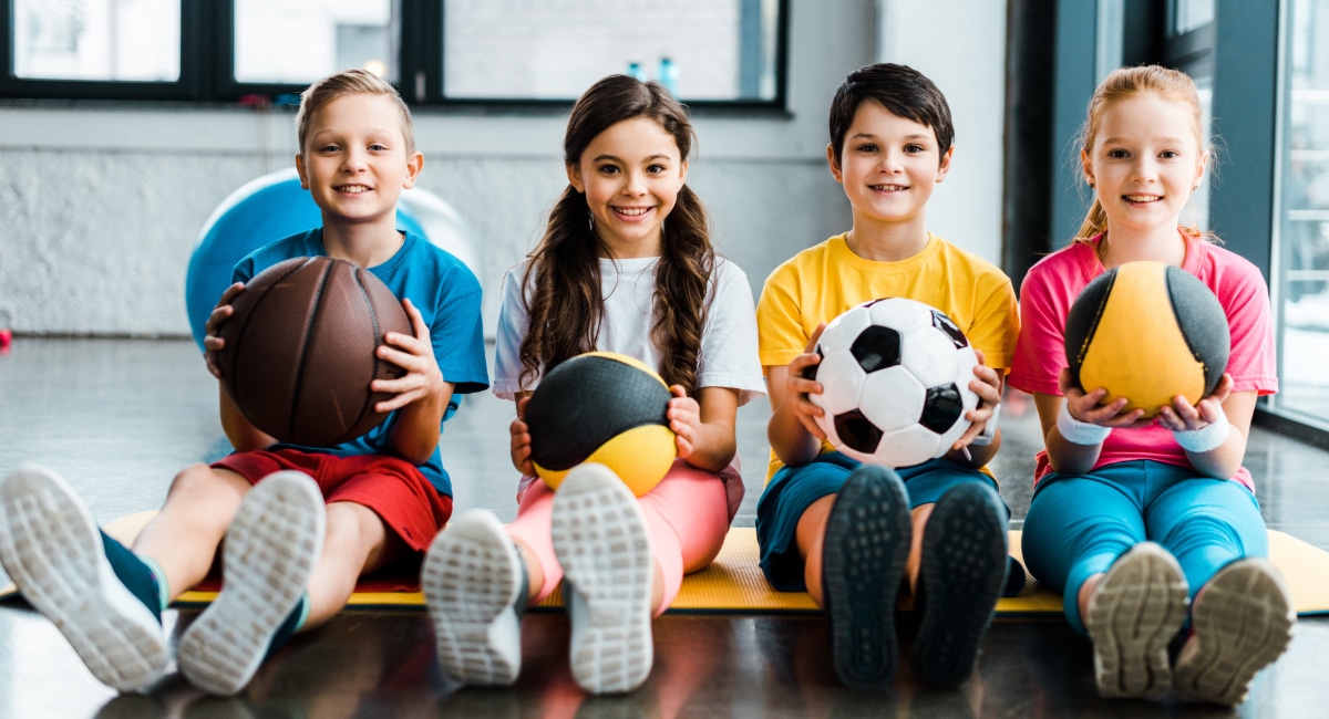Children holding different sports balls